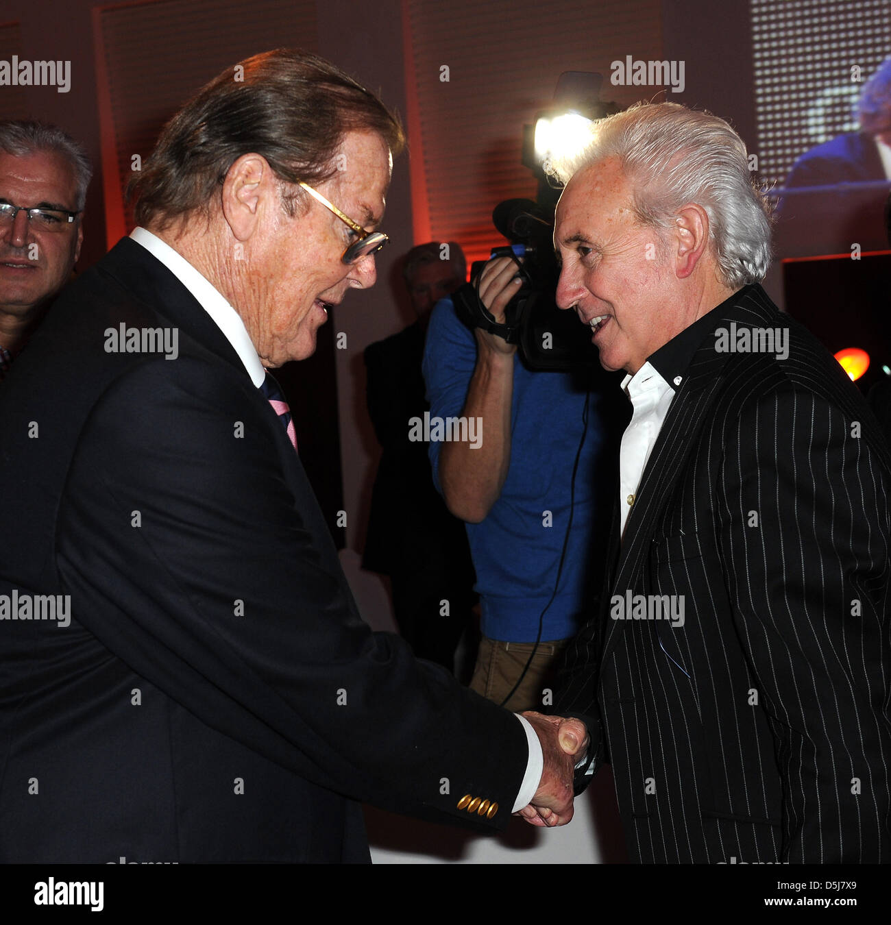 British singer Tony Christie (r) and British actor Sir Roger Moore greet at the Get Together Party of the Hermes Eagles Golf cup at Nobilis Robinson Club in Belek, Turkey, 16 November 2012. Celebrities from sports, film and economy play for foundations such as the childrens emergency funds and the Beckenbauer foundation. Photo: Ursula Dueren Stock Photo