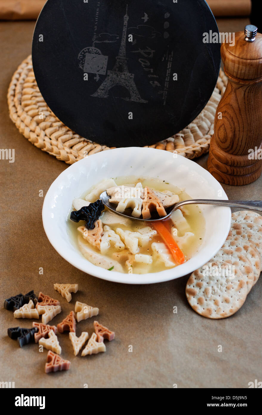 Chicken soup with Eiffel Tower noodles. Stock Photo