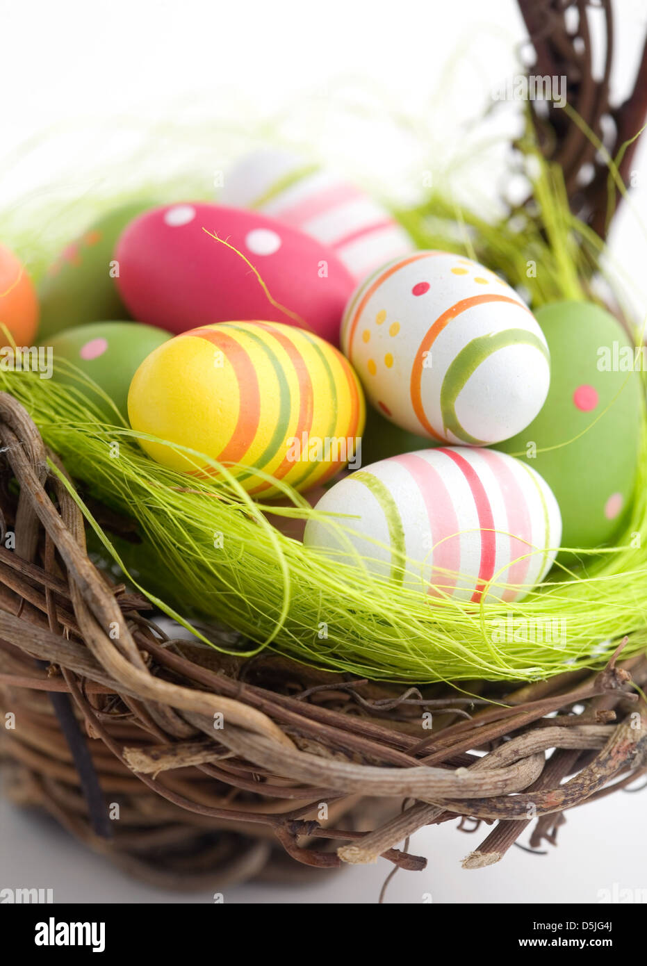 Colorful painted easter eggs in brown basket Stock Photo - Alamy