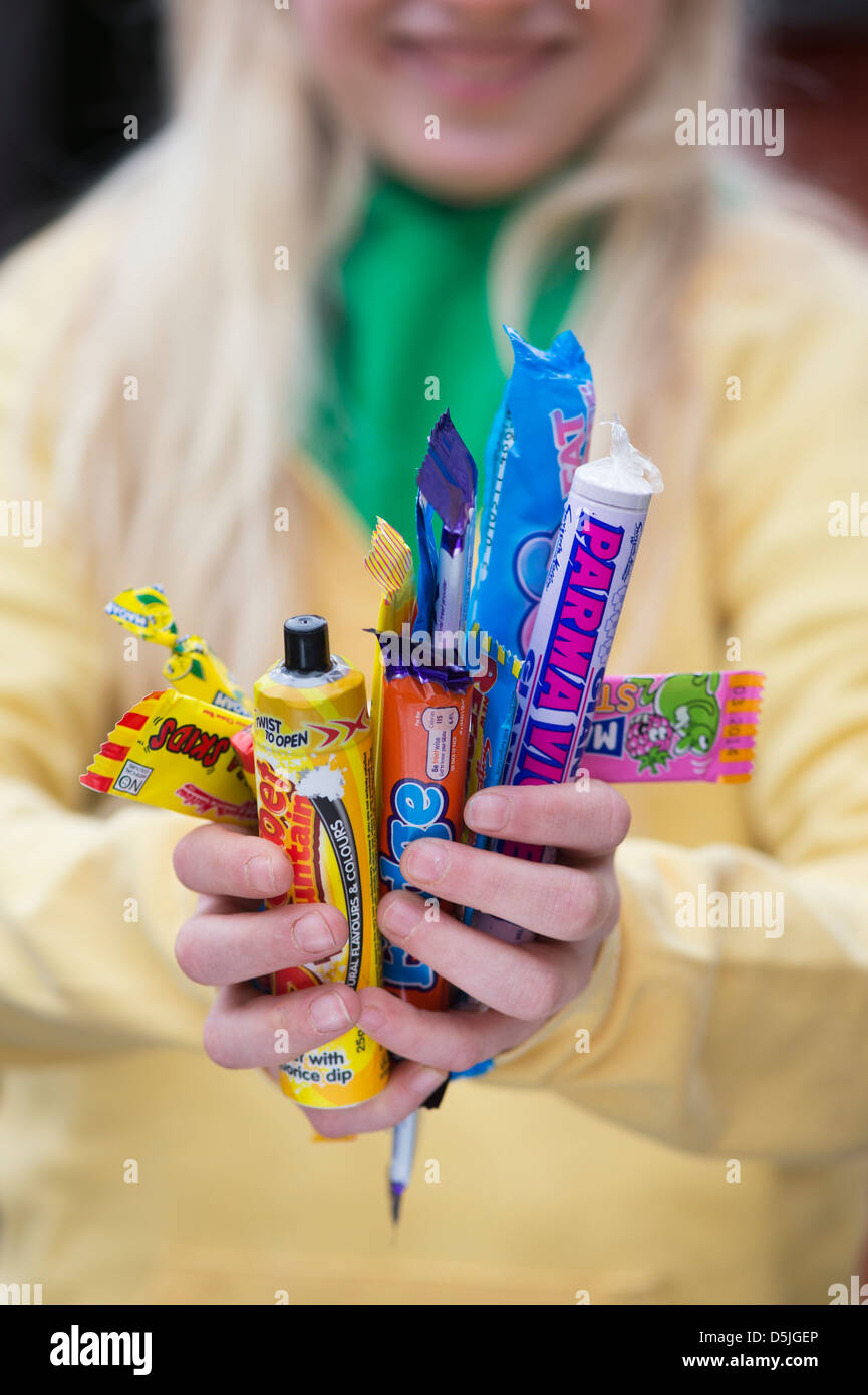 Girl hands holding assorted childrens retro sweets and candy Stock Photo