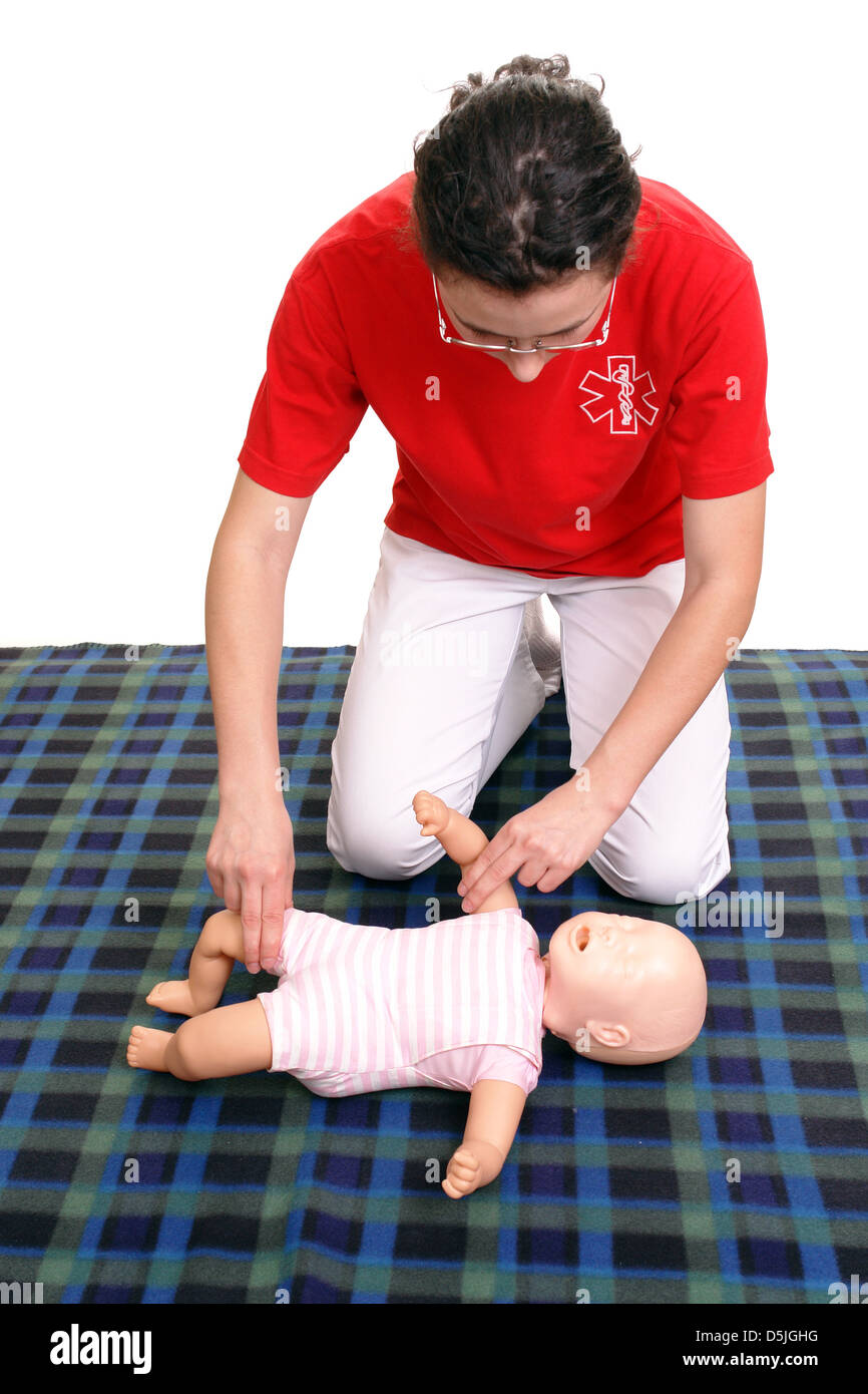 First aid instructor showing how to check pulse on infant dummy Stock Photo