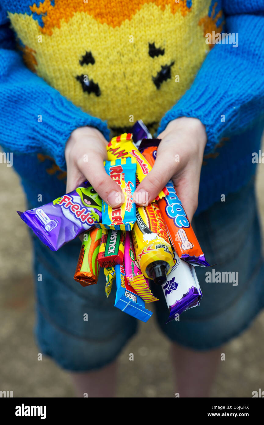 Boys hands holding assorted childrens retro sweets and candy Stock Photo