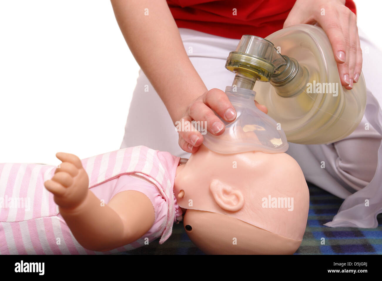 First aid instructor demonstrating artificial respiration using respirator on infant phantom Stock Photo