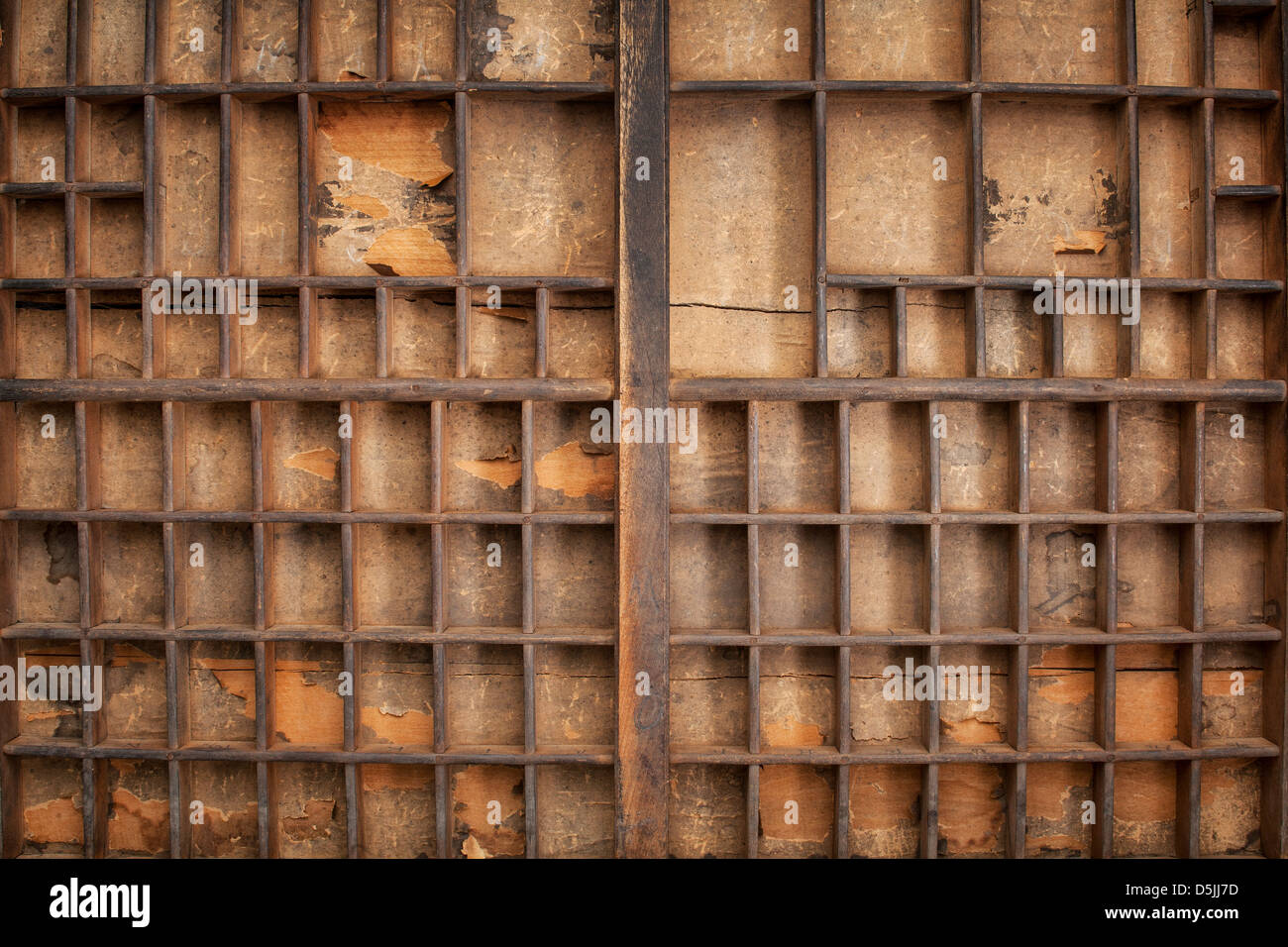 grunge wood typesetter drawer with numerous dividers and decaying paper liner Stock Photo