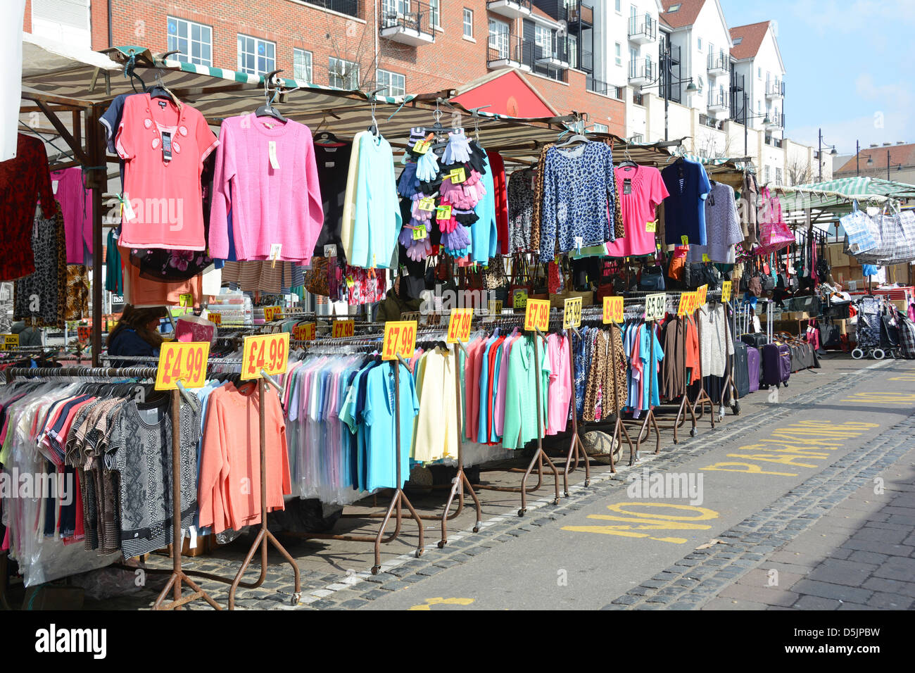 Romford market stall with bargain clothing on hanging rails with price tags Stock Photo