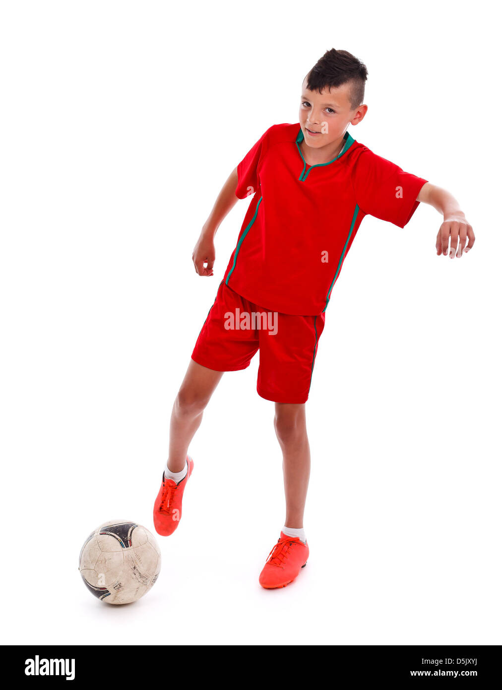 Young boy in uniform kicking the soccer ball white background Stock