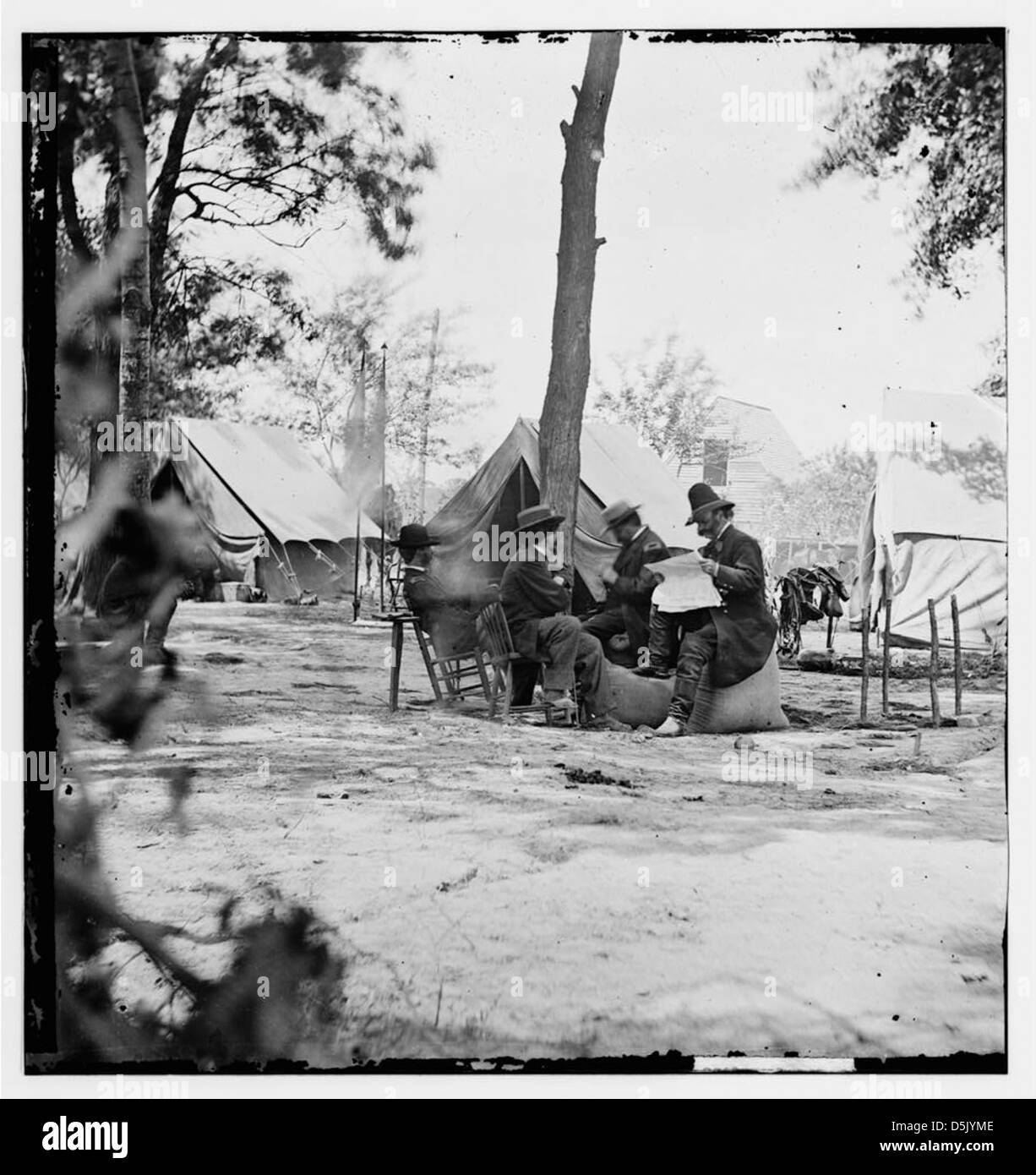 [Gen. Ambrose E. Burnside (reading newspaper) with Mathew B. Brady (nearest tree) at Army of the Potomac headquarters] (LOC) Stock Photo
