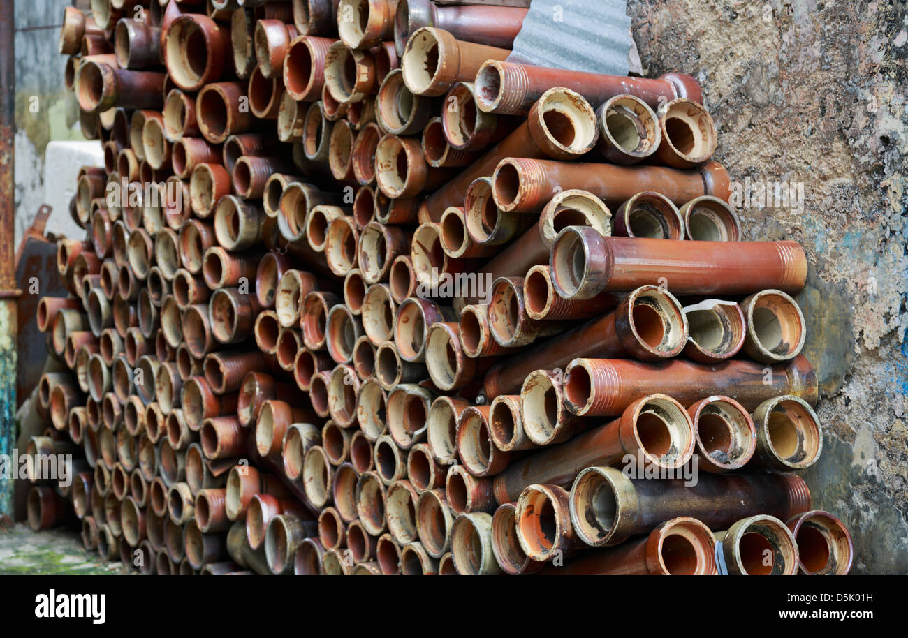 A stack of abandoned ceramic pipes seen in an alley Stock Photo