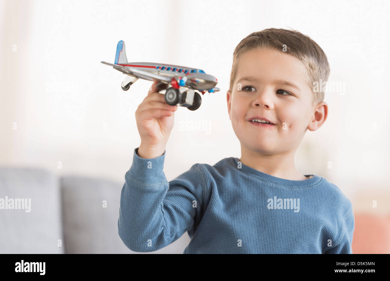 Boy (4-5) playing with toy plane Stock Photo