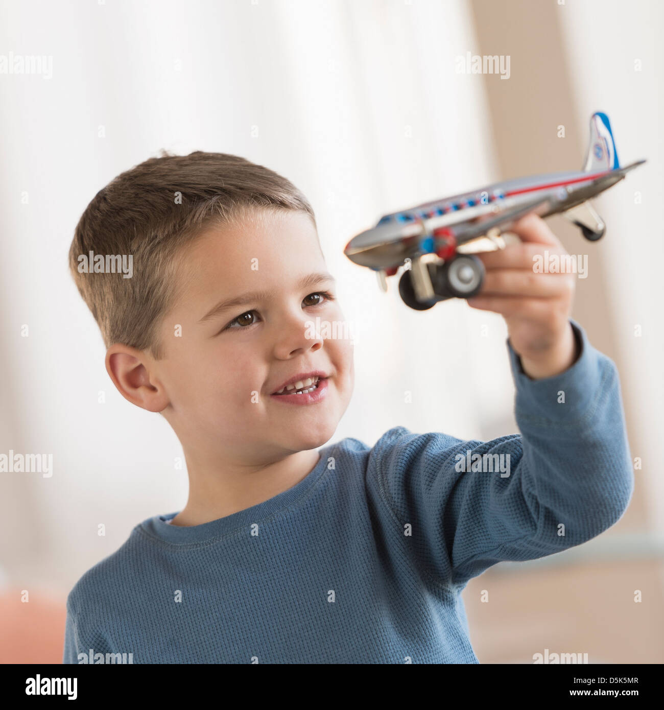 Boy (4-5) playing with toy plane Stock Photo