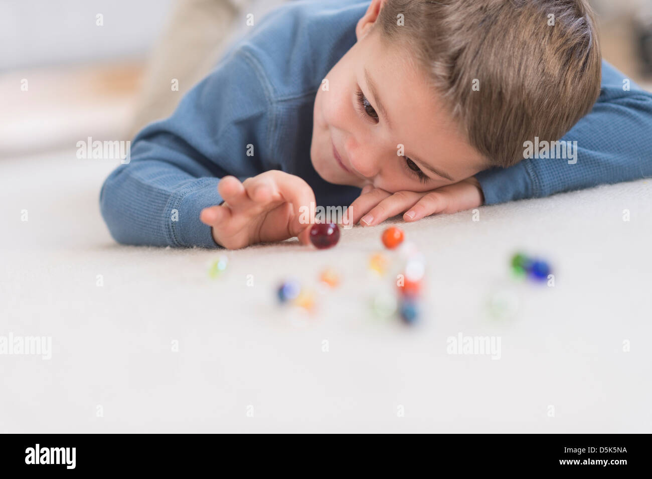 Boy (4-5) playing with marbles Stock Photo
