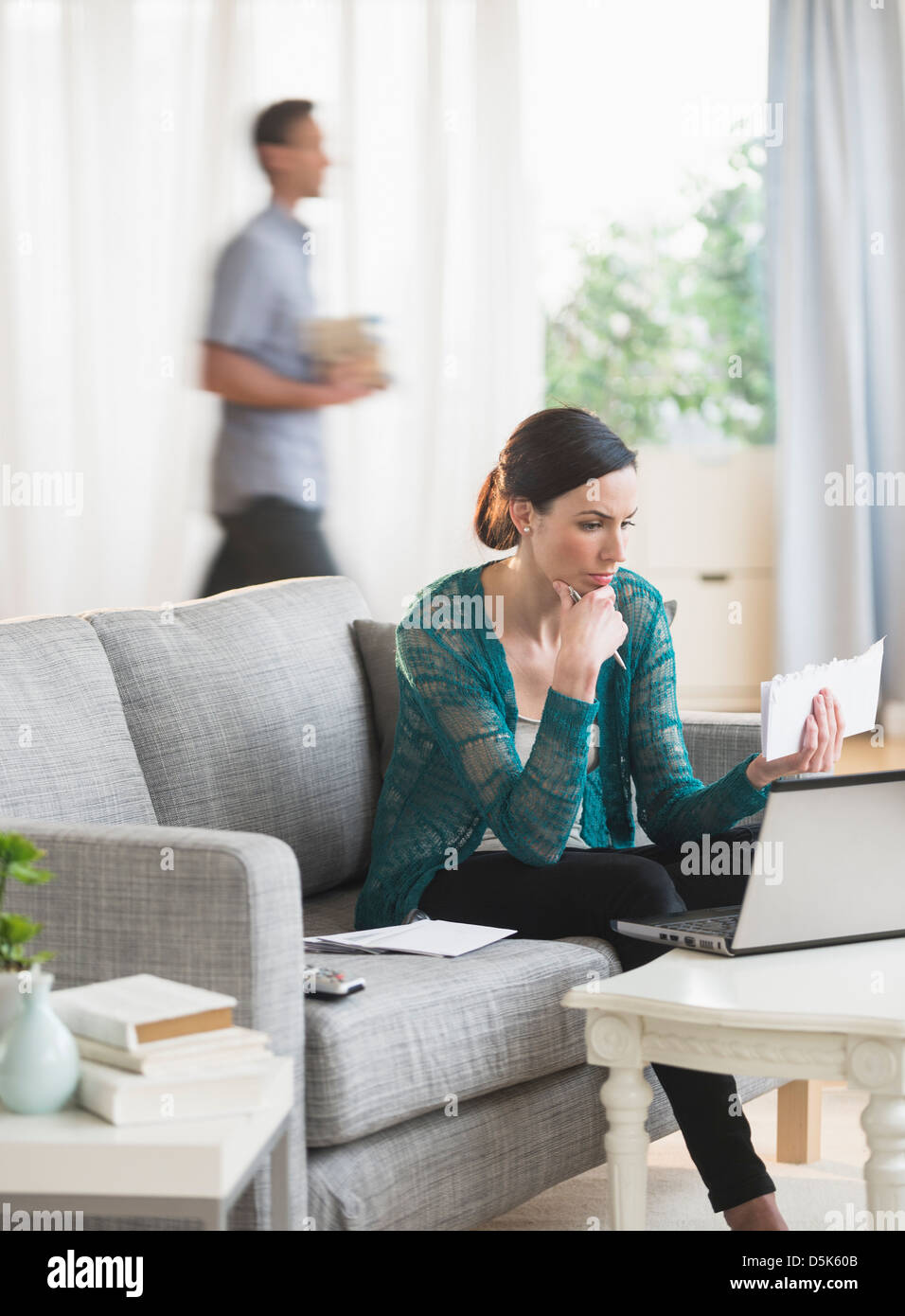Woman using laptop to pay bills Stock Photo
