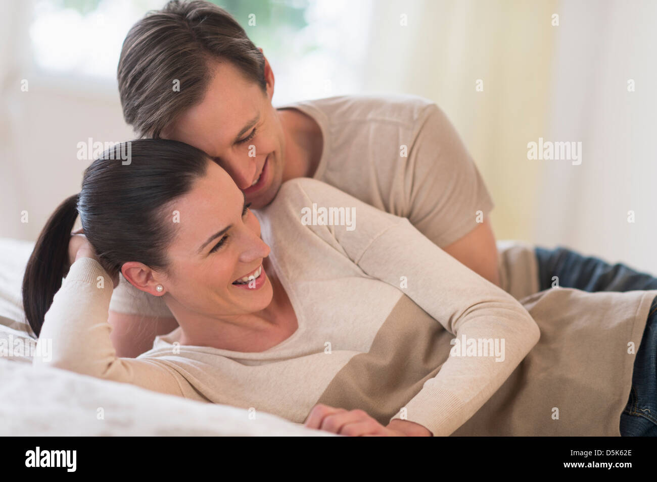Couple lying together on bed hi-res stock photography and images - Alamy