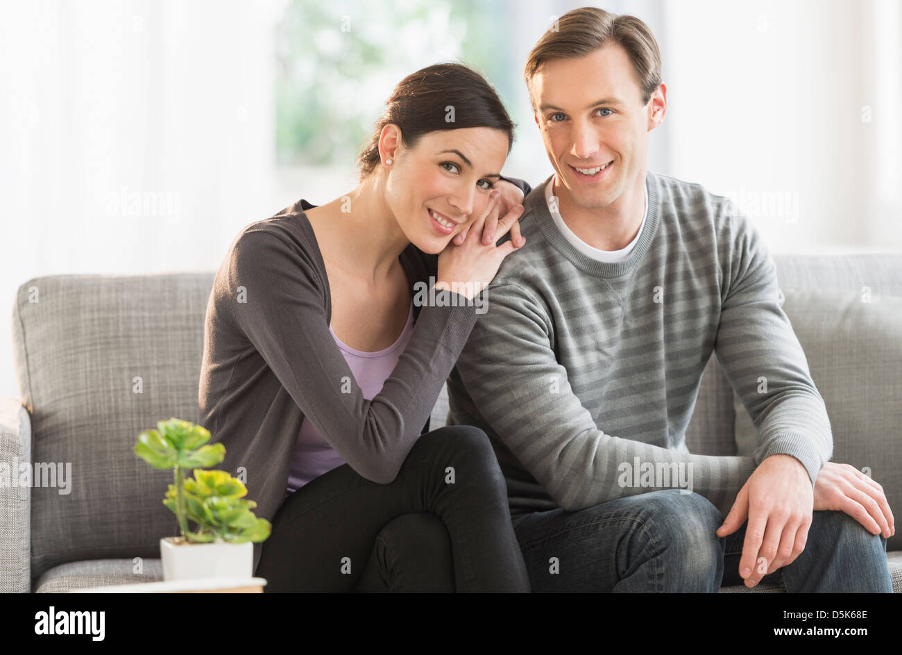 Loving couple embracing on sofa hi-res stock photography and images - Alamy