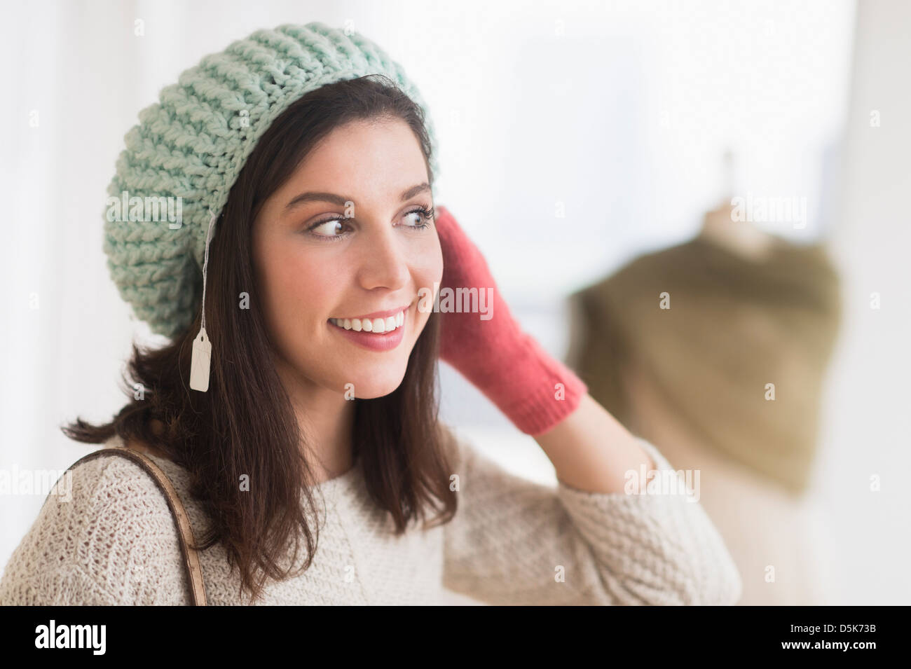 Woman trying on knit hat Stock Photo
