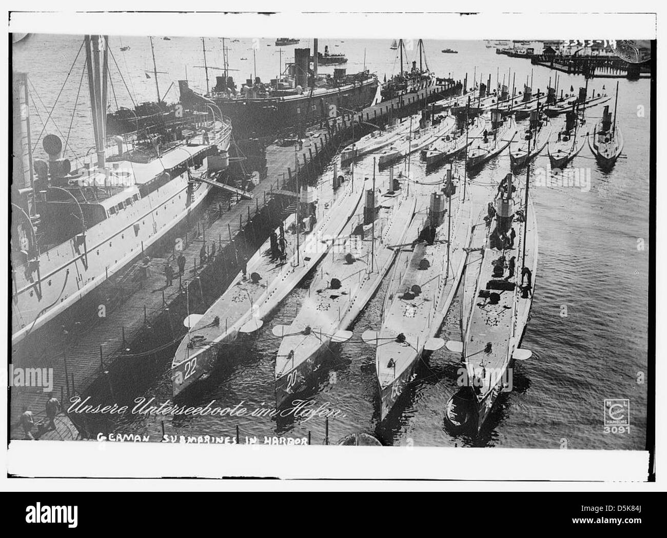 This image shows German U-boats docked in a harbor in Hamburg, Germany, during World War I. The submarines are pictured at rest, with several visible in the background. The photo is preserved by the Library of Congress. Stock Photo