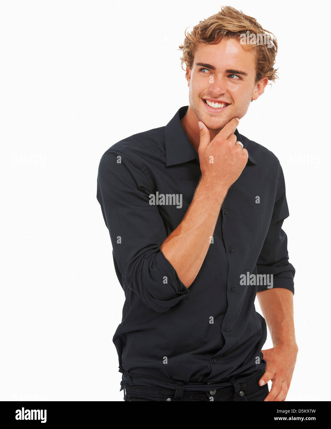 Studio Shot, Portrait of young man standing, hand on chin Stock Photo