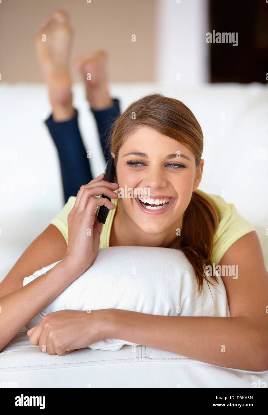 Young woman lying on bed and talking on phone Stock Photo Alamy