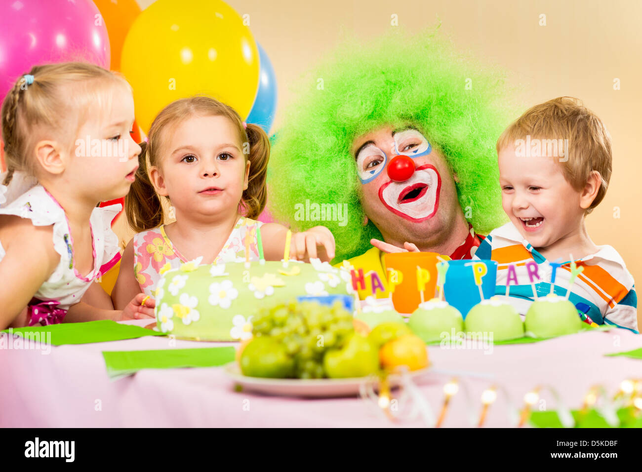 kids celebrating birthday party with clown Stock Photo