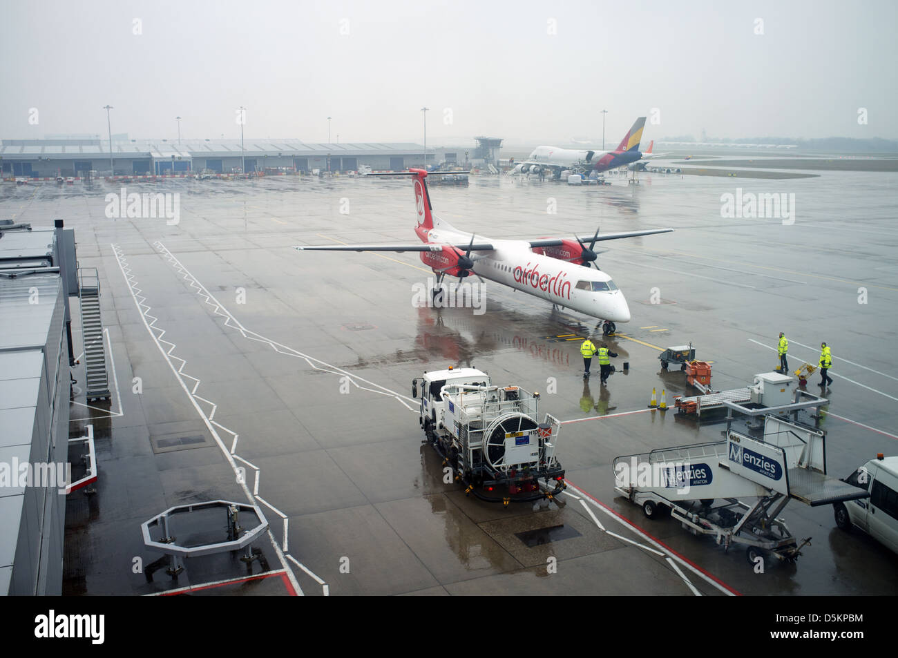 Ground staff await the arrival of an Air Berlin turbo-prop passenger aircraft, Stansted airport, Essex, UK. Stock Photo