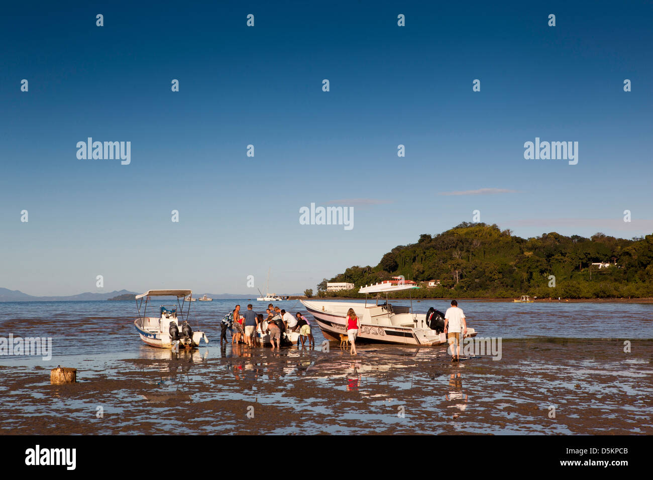 Madagascar, Nosy Be, Marodokana, Operation Wallacea student pushing dive boat out of mud at low tide Stock Photo