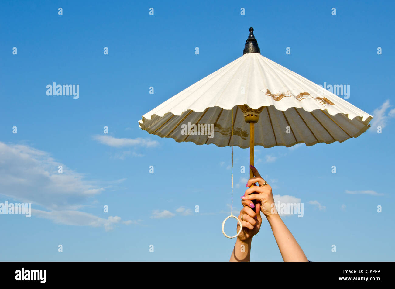 girl hands holding paper umbrella on summer sky background Stock Photo -  Alamy