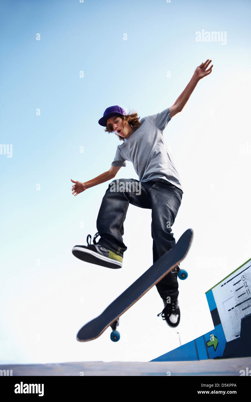 Skater performing jump in skateboard park Stock Photo Alamy
