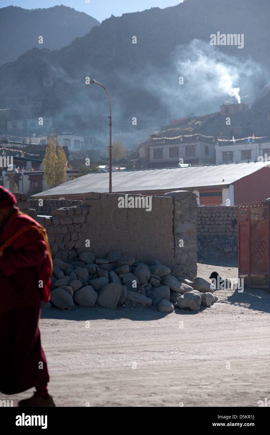 A passing monk and homeless street dog in the mountain town of Leh, Ladakh, Jammu and Kashmir. India. Stock Photo