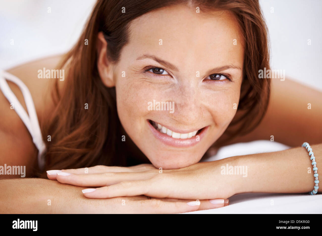 Woman smiling hands clasped hires stock