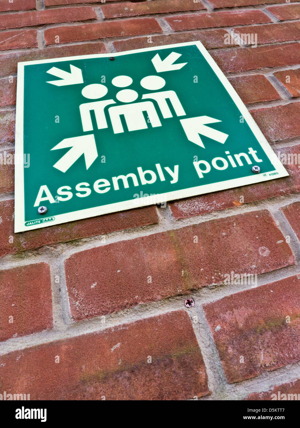 Assembly point sign on a wall. Stock Photo