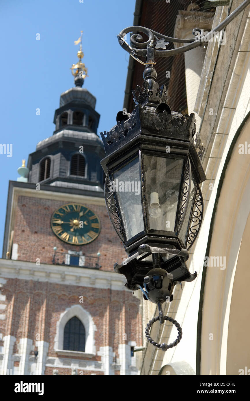 Closeup of ornamental street lantern with historical Medieval Town Hall tower in the background - Krakow, Poland Stock Photo