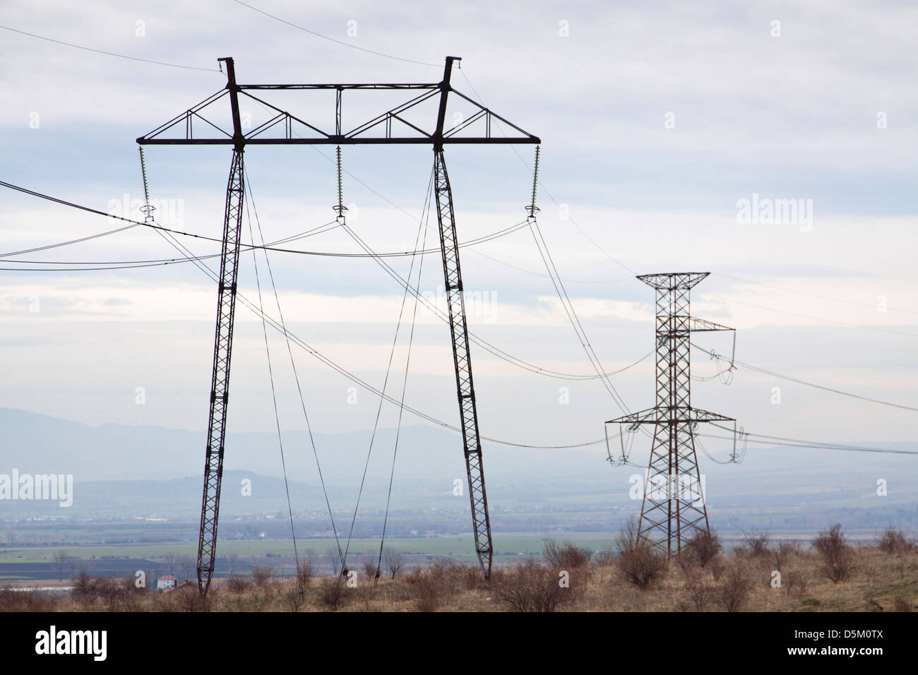 Steel lattice high voltage transmission towers, the outskirts of the Bulgarian capital Sofia in the background Stock Photo