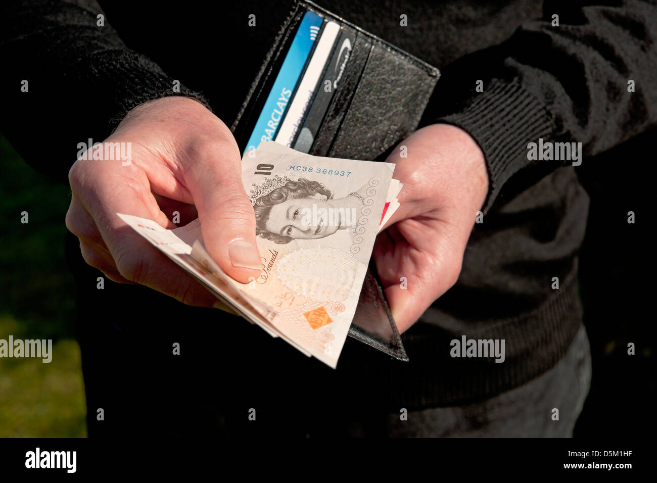 close up of man person holding wallet and 10 ten pound pounds note D5M1HF