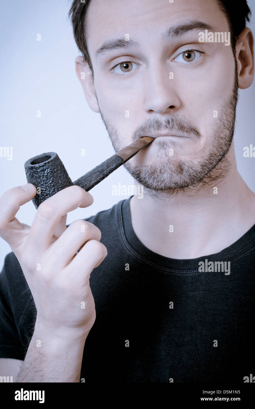 Young man smoking pipe Stock Photo