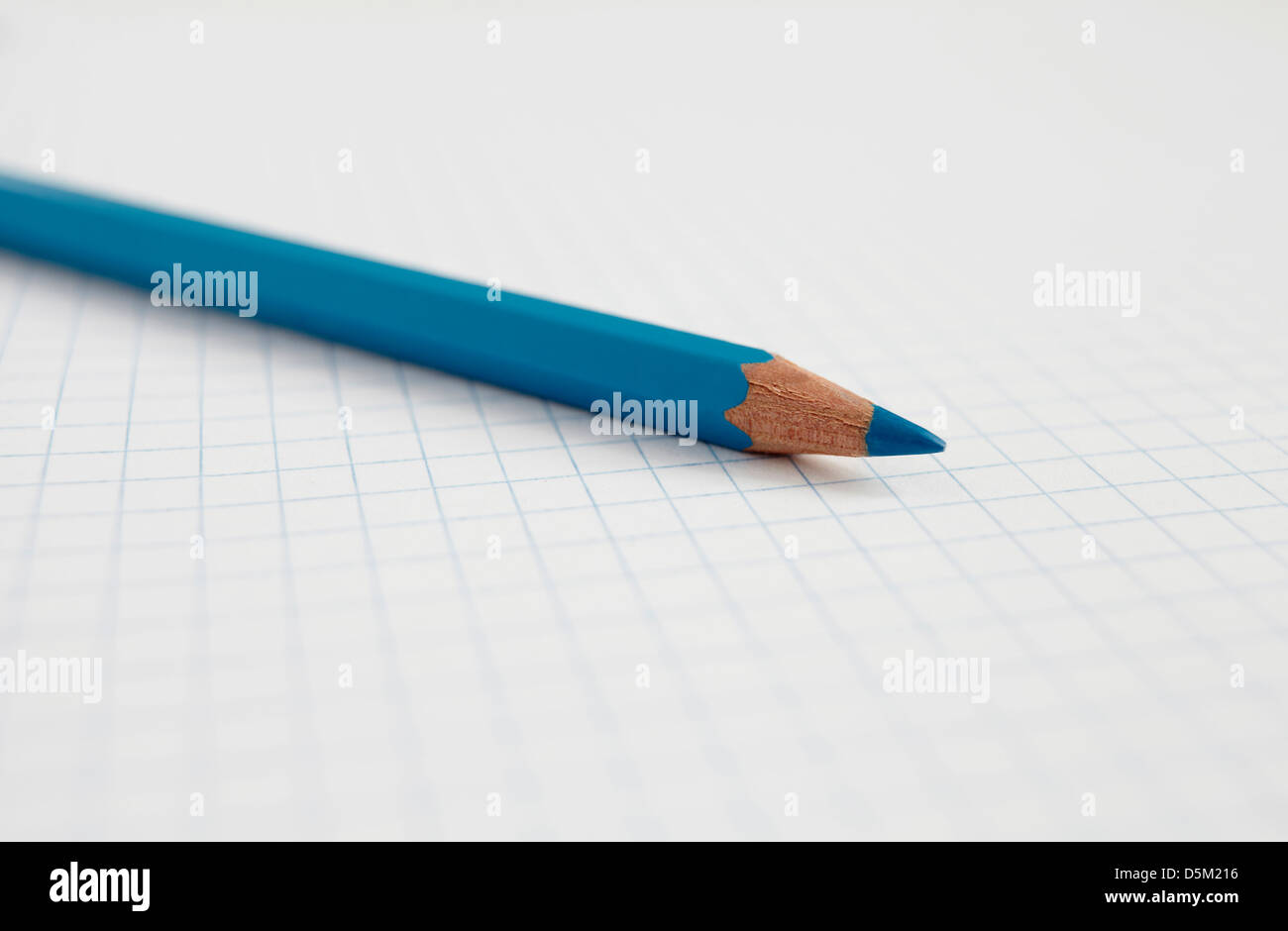 Blue pencil on graph paper, studio shot Stock Photo