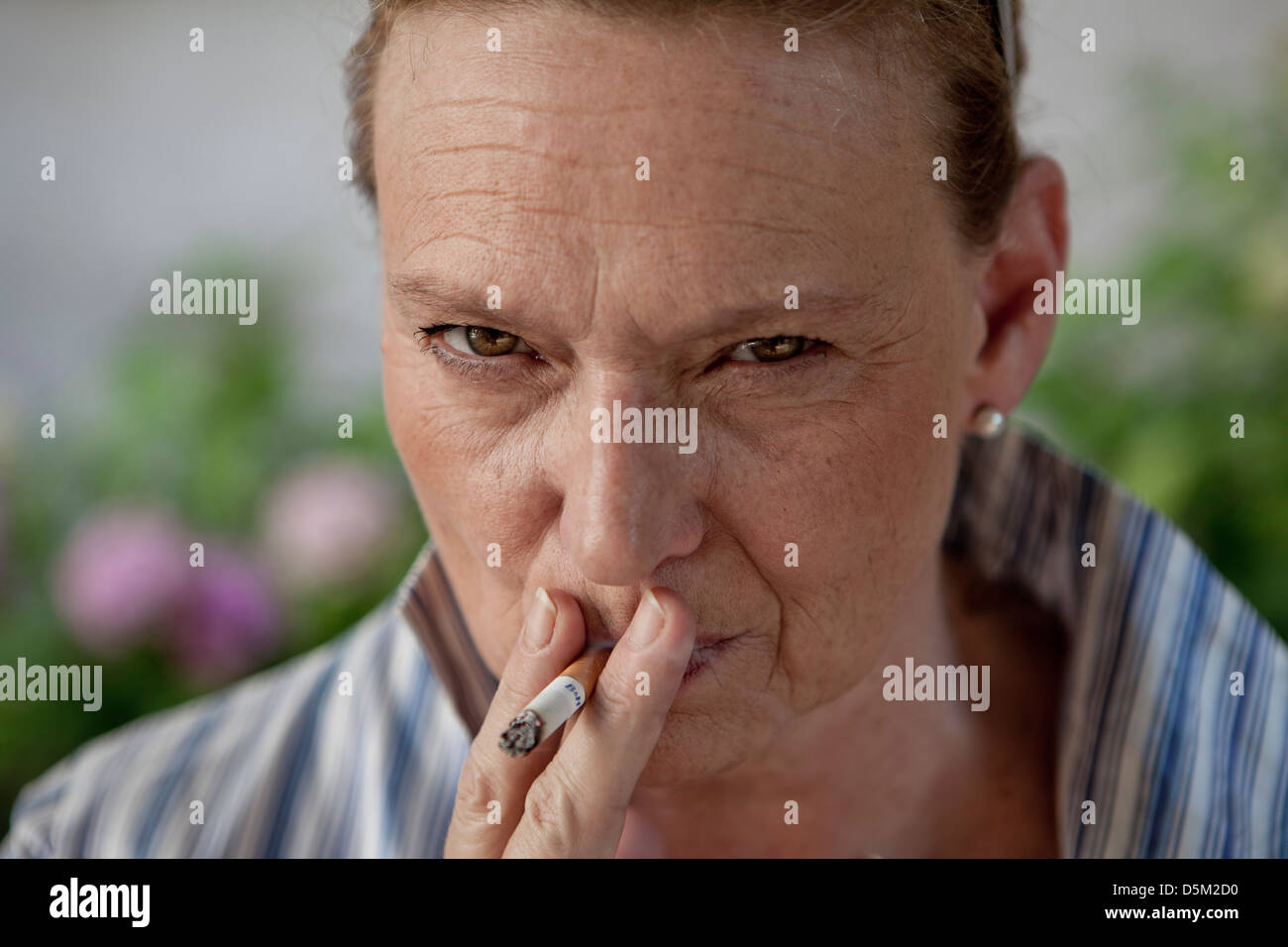 angry woman smoking a cigarette Stock Photo