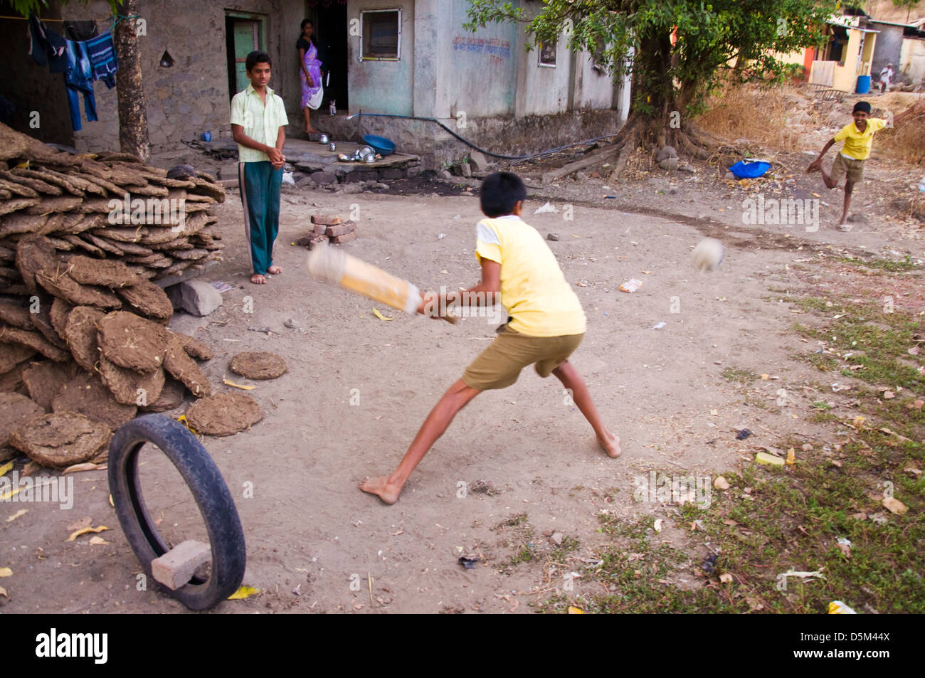 Rural Indian boys playing cricket in Mulshi Valley Paud Maharashtra India Stock Photo