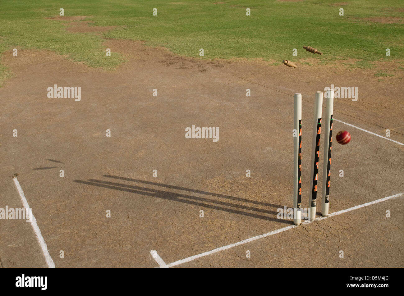 Cricket ball striking stumps Stock Photo