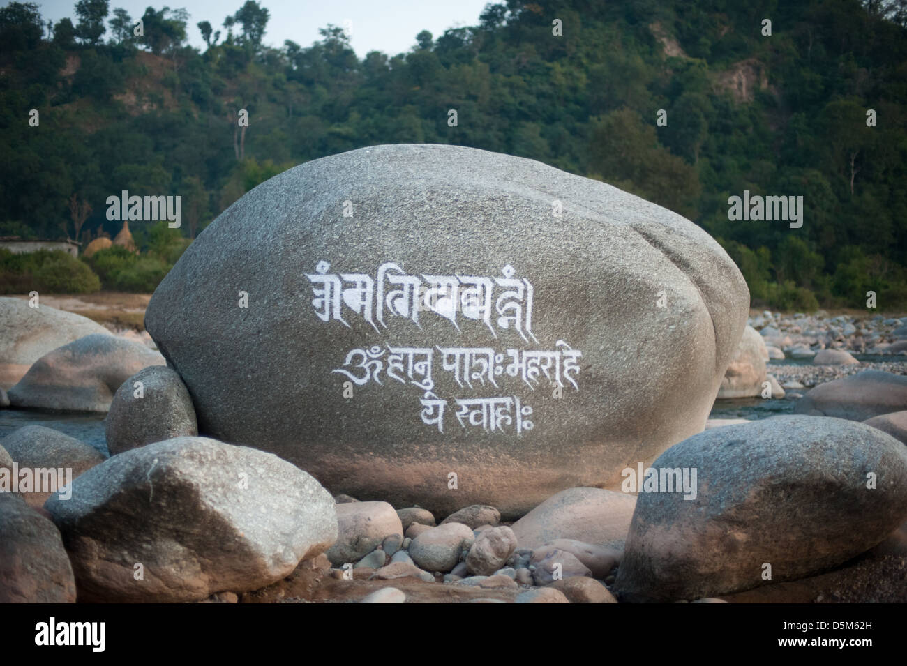 A Tibetan mantra is carved on a huge boulder in a riverbed, under Dharamshala, India: The home in exile of the Dali Lama and thousands of Tibetans. Stock Photo