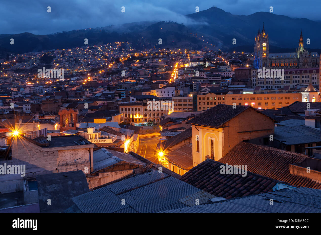 Quito, Ecuador old town and basilica at night with mountains in the background Stock Photo