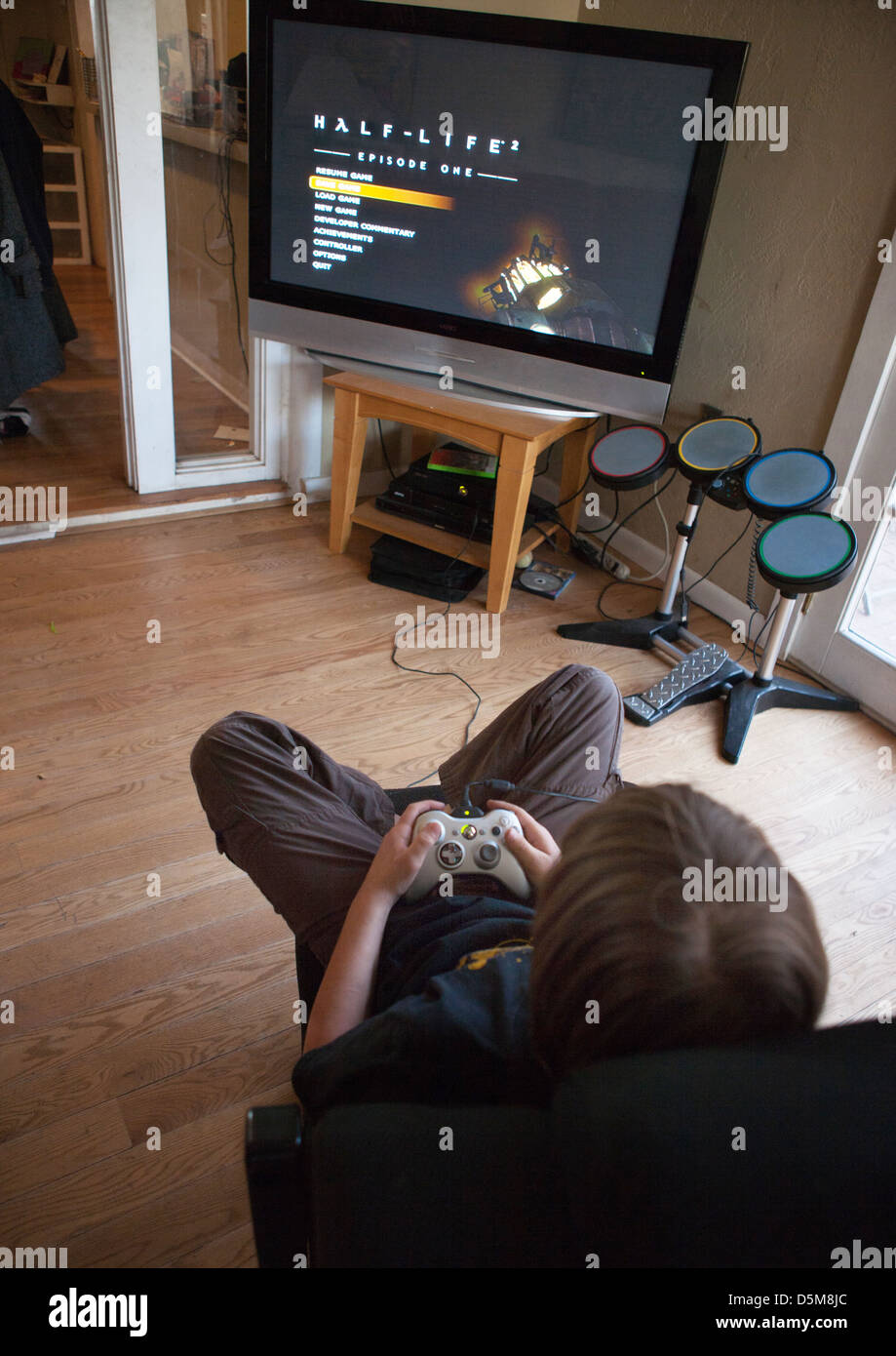 Ten year old boy sitting at home playing the video game Half Life Stock