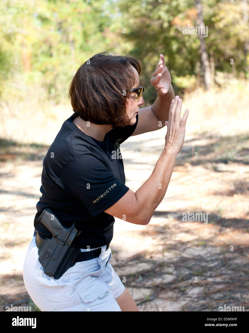 Women with holstered gun showing startled response from a threat Stock