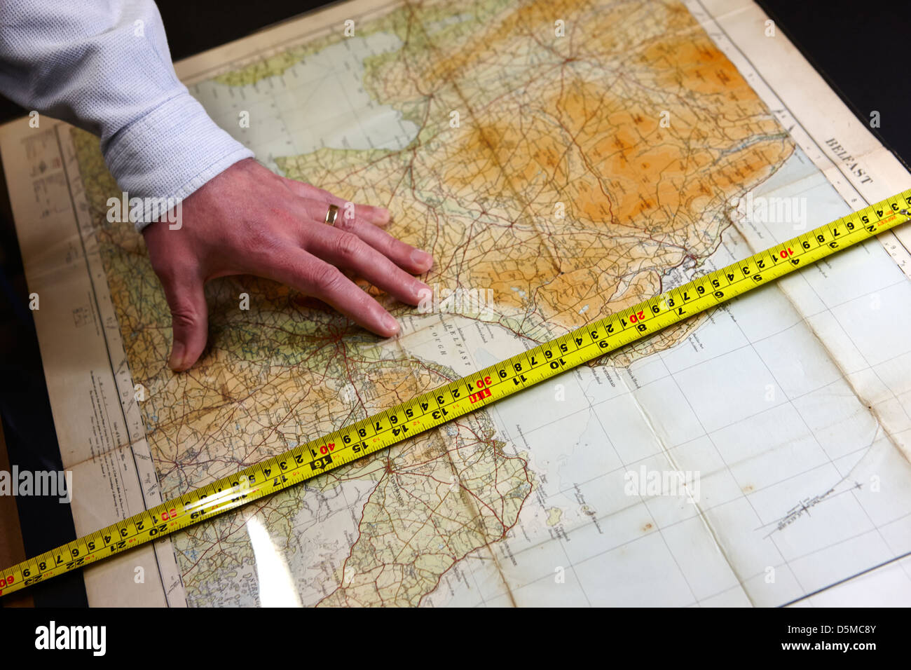 framer measuring historical map for frame in a framing Stock