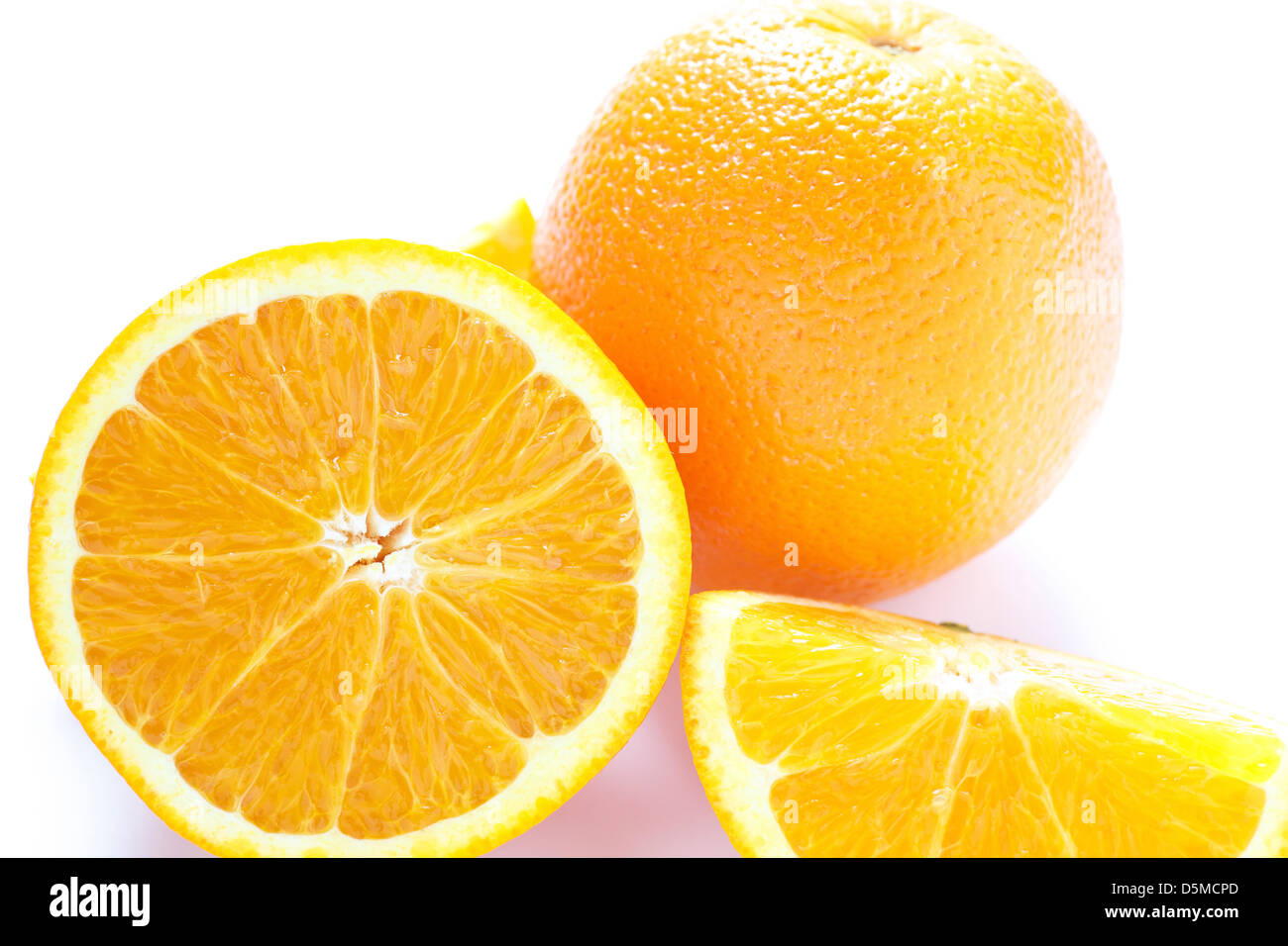 whole and cut oranges on a white counter Stock Photo Alamy