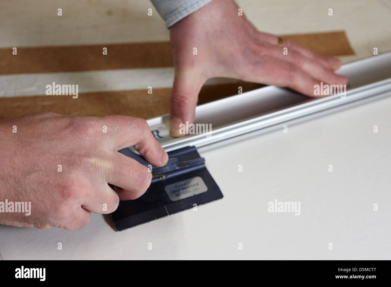 framer manually cutting mount board in a framing Stock Photo