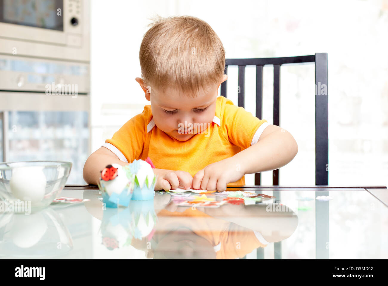 child boy decorate easter eggs indoors Stock Photo