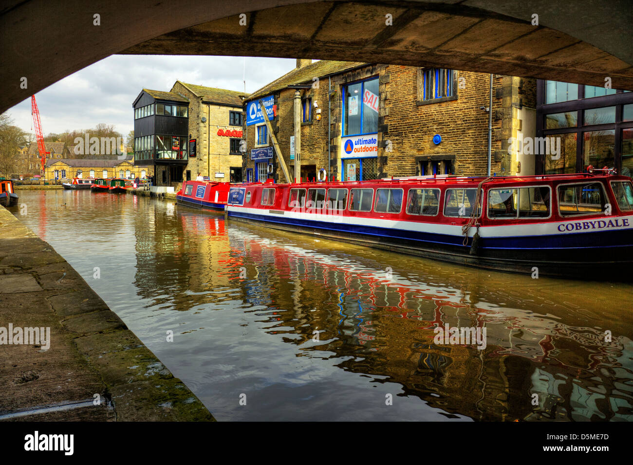 Narrow Boats Barges on Skipton Leeds and Liverpool canal on the river Aire barge boats moored and sailing down river Stock Photo