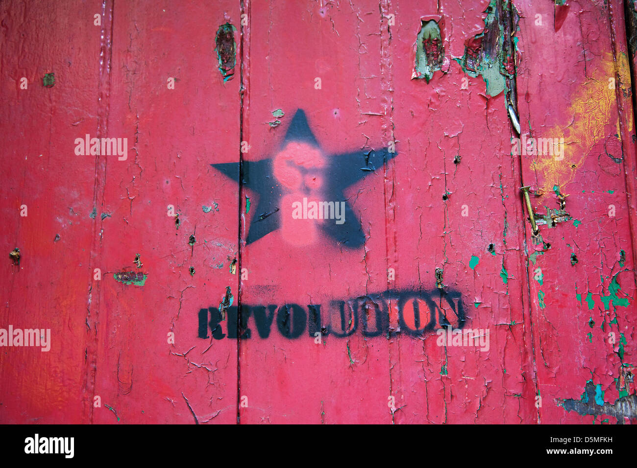 Revolution graffiti sprayed on old red door Stock Photo