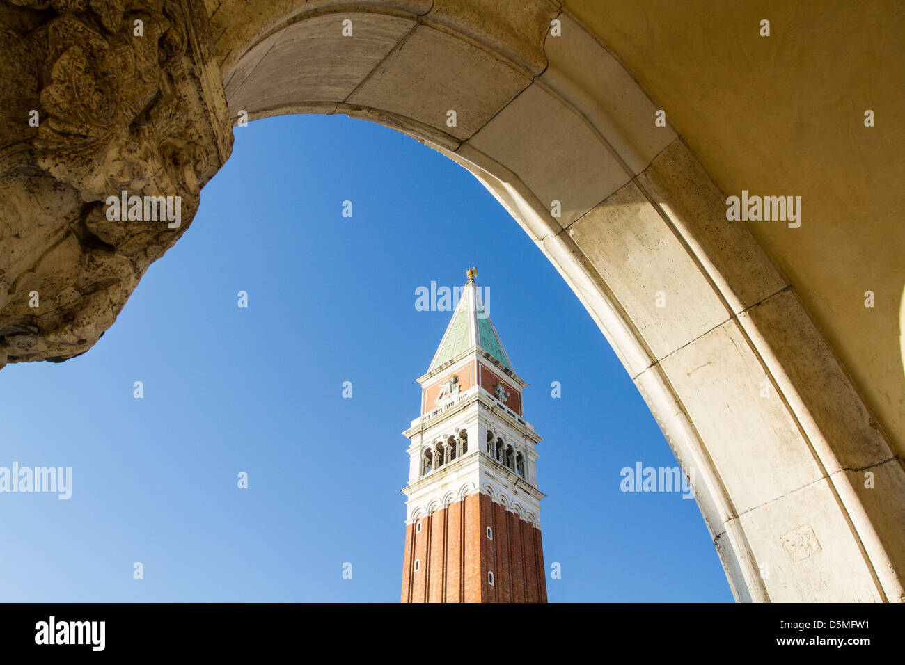 Saint Mark Campanile (Campanile di San Marco) viewed from the arches of Doge's Palace (Palazzo Ducale). Stock Photo