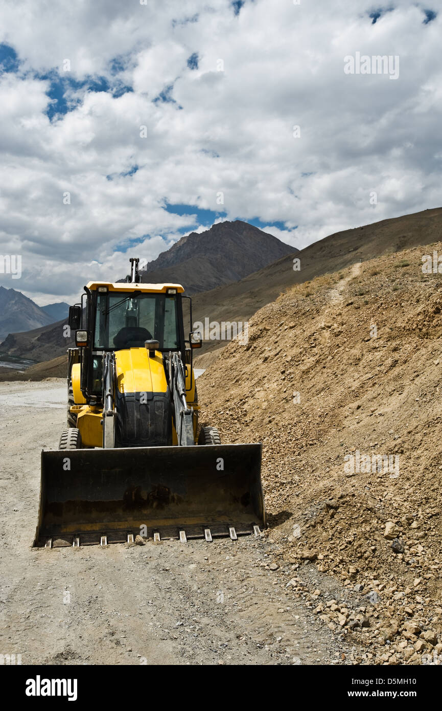 yellow bulldozer on mountain road Stock Photo